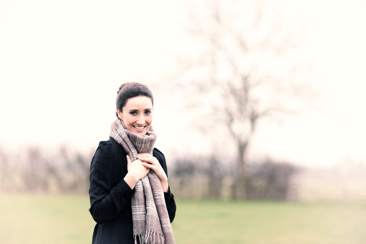 Wedding Singer Saira Luther wearing thick scarf in a field